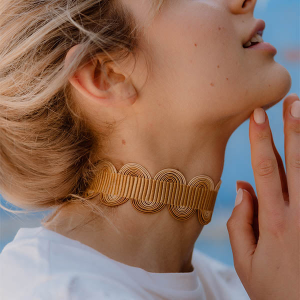 ragazza indossa collana girocollo choker argento nastro passamaneria onde giallo oro made in italy
